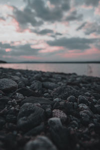 Rocks on beach against sky during sunset