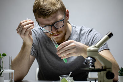 Portrait of young man with eyeglasses on table