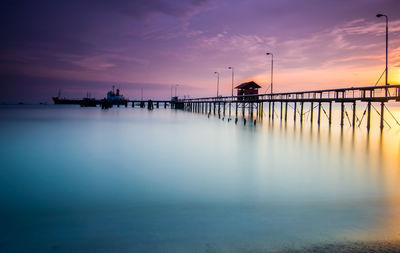 Pier over sea against sky during sunset