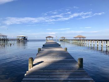 Wooden pier over sea against sky