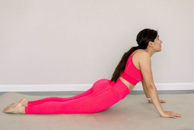 Side view of woman sitting on floor