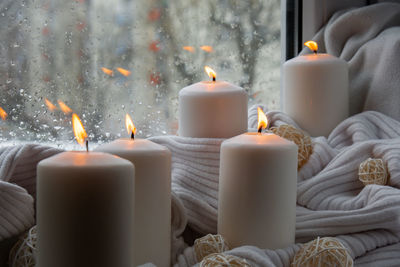 Close-up of illuminated candles on table