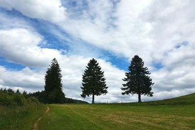 Scenic view of grassy field against cloudy sky