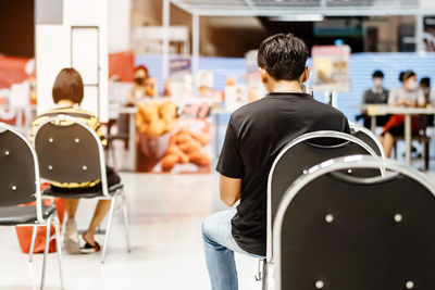 Rear view of people sitting on chair