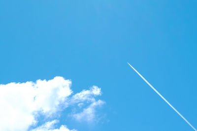 Low angle view of vapor trail in blue sky