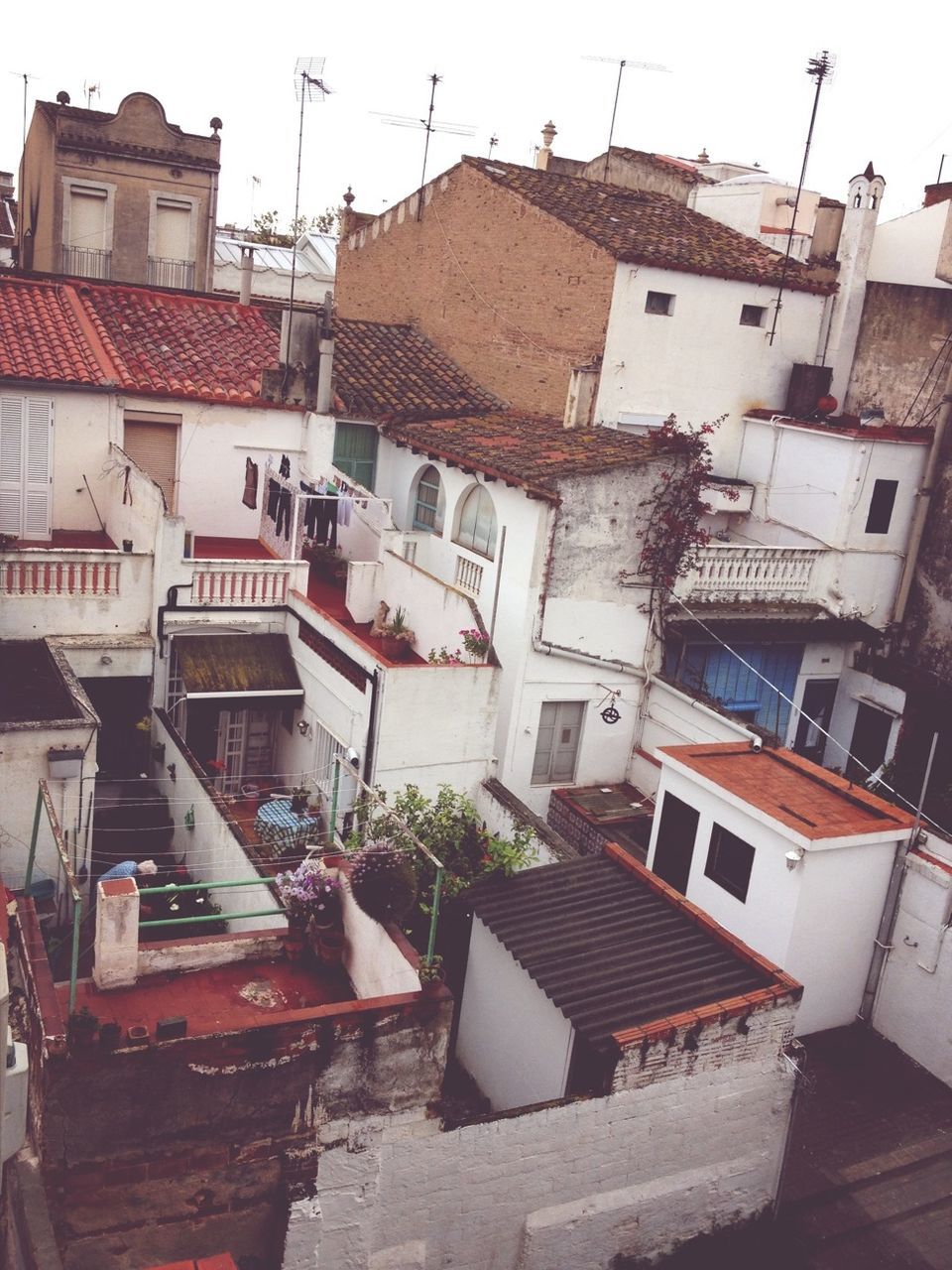 building exterior, architecture, built structure, house, residential structure, roof, residential building, residential district, roof tile, town, rooftop, high angle view, building, day, outdoors, townscape, clear sky, sky, city, no people