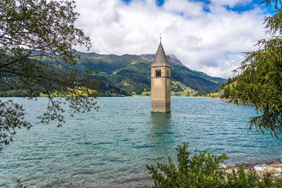 Scenic view of lake by buildings against sky