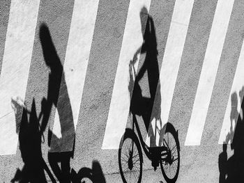 Shadow of women riding bicycle on road