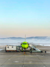 Airplane on airport runway against clear sky