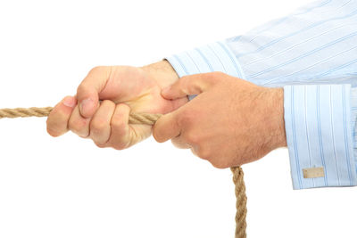 Close-up of man holding hands over white background