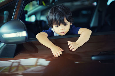 Cute boy sitting in car