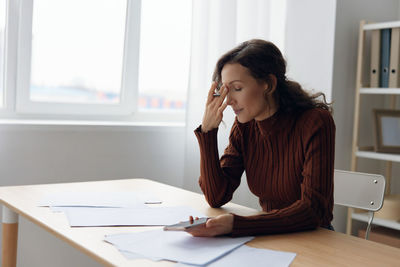 Businesswoman holding smart phone at office