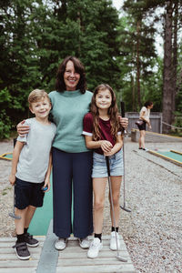 Full length of portrait of senior woman with family standing in backyard