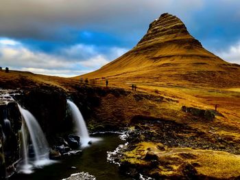 Scenic view of waterfall against sky
