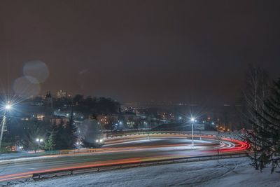 Light trails on road in city at night during winter