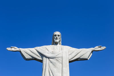 Low angle view of statue against blue sky