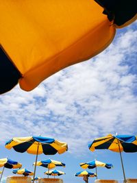 Low angle view of yellow umbrella against sky