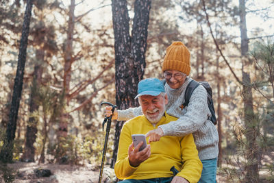 Side view of young woman standing in forest