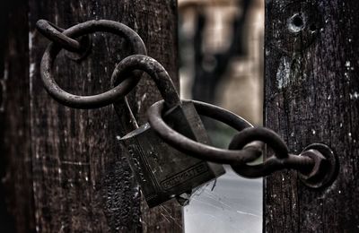 Close-up of padlock on chain at gate