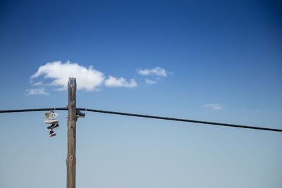 Low angle view of power line against blue sky