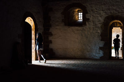 Silhouette people walking in corridor of historic building