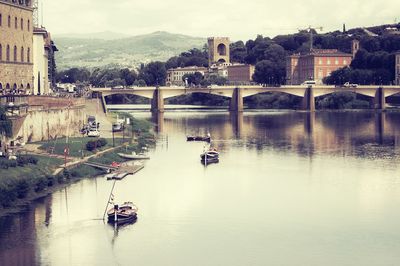 Boats in river with city in background