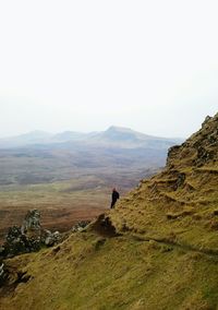 Man walking on mountain against clear sky