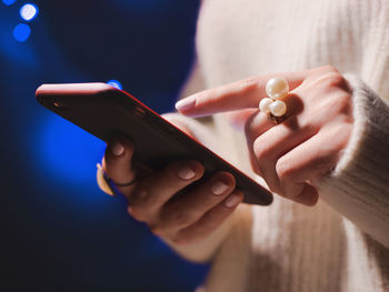 Close-up of woman holding mobile phone