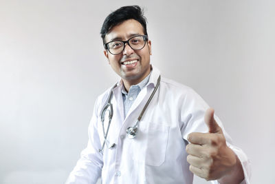 Portrait of smiling young man against gray background