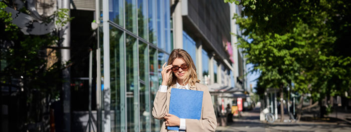 Side view of woman standing against building