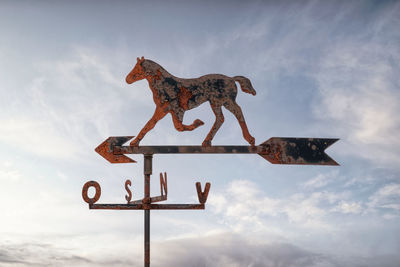 Weather vane with a horse figure on an arrow showing the wind direction