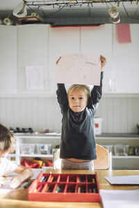 Portrait of cute boy standing in cafe