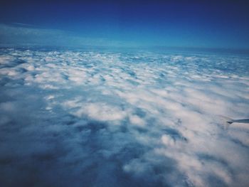 Aerial view of clouds over snow covered landscape