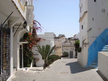 Footpath amidst buildings against sky