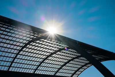 Modern glass roof in sunlight against blue sky