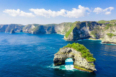 Scenic view of rock formation in sea against sky