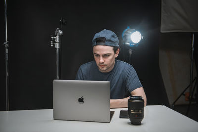 Young man using laptop on desk in studio