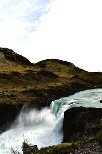 Scenic view of waterfall against sky