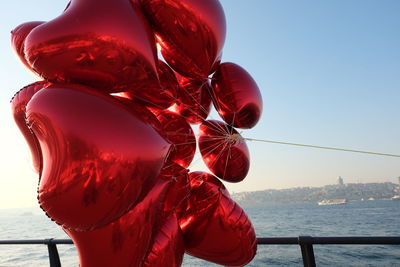 Close-up of red balloon against sea