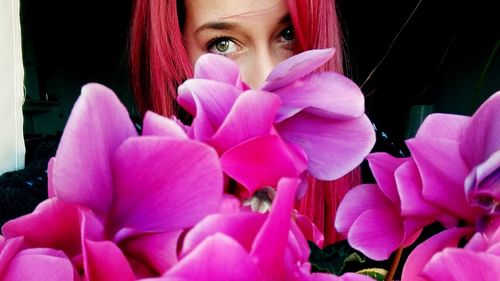 Close-up of young woman with pink flowers