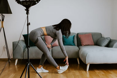 Woman sitting on sofa at home