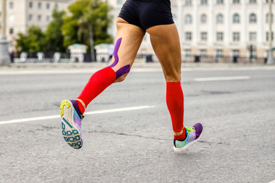 Low section of woman walking on road