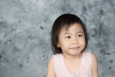 Charming 4 year old cute baby asian girl, child with adorable short hair smiling. copy space.