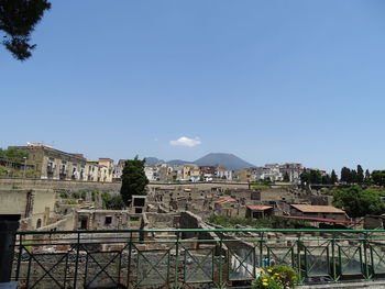 Buildings in town against clear blue sky