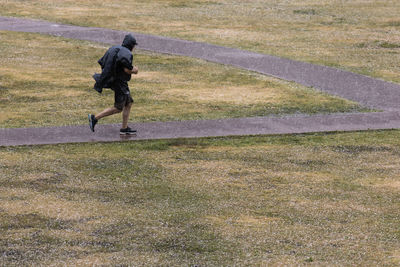 Rear view of man running on field