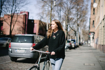 Woman with bicycle in city