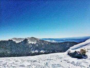 Scenic view of snow covered mountains against clear sky