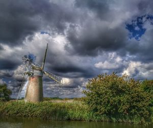 Traditional windmill on field against sky