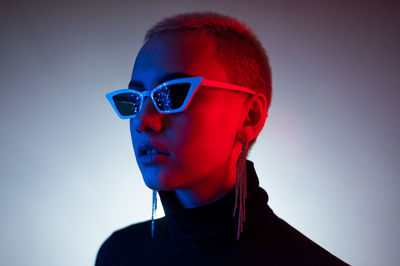 Portrait of boy wearing sunglasses against blue background