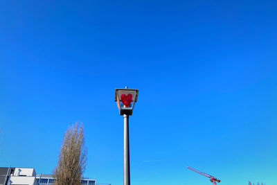 Low angle view of street light against clear blue sky